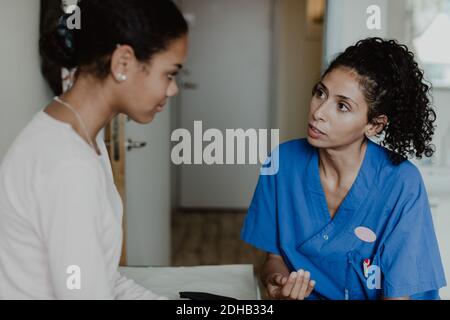 Ärztin im Gespräch mit dem Patienten im medizinischen Raum im Krankenhaus Stockfoto