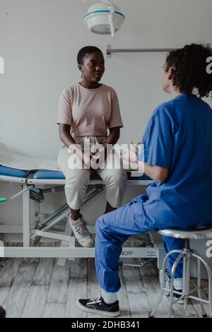 Ärztin im Gespräch mit dem Patienten im medizinischen Raum im Krankenhaus Stockfoto