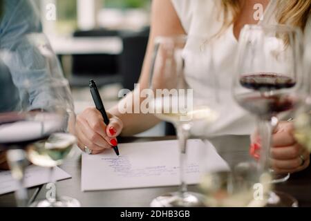 Geschäftsfrau, die während des Kick-off-Meetings in der Convention auf Papier schreibt Zentrieren Stockfoto