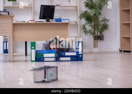 Junger männlicher Angestellter und Mausefalle im Büro Stockfoto
