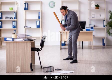 Junger männlicher Angestellter und Mausefalle im Büro Stockfoto
