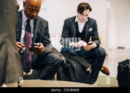 Führungskräfte, die im Büro mit Mobiltelefonen arbeiten Stockfoto