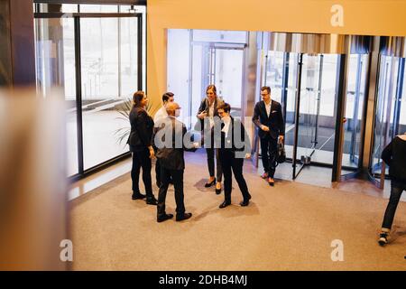 Kollegen, die in der Bürolobby die Hände von Geschäftsleuten schütteln Stockfoto