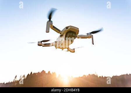 Nahaufnahme eines DJI Quadcopter Drone Mavic mini 249g. Drohne, die vor Sonnengrund fliegt. Stockfoto