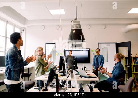 Geschäftskollegen klatschen in einem Büromeeting um lächelnde Redner Stockfoto