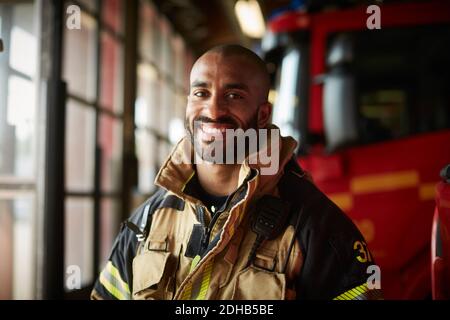 Porträt eines lächelnden männlichen Feuerwehrmichters in Uniform in der Feuerwehr Stockfoto