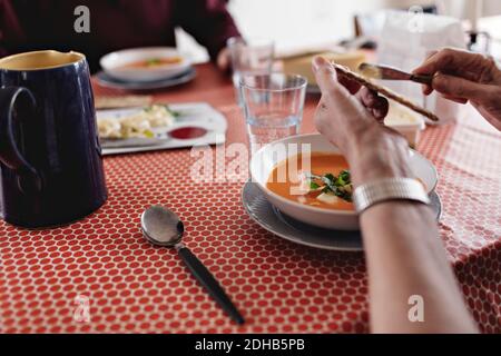 Zugeschnittenes Bild eines älteren Ehepaares, das beim Essen sitzt Tabelle Stockfoto