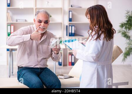 Alter Mann besucht junge Ärztin für plastische Chirurgie Stockfoto