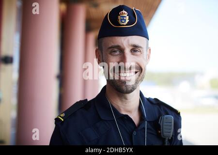 Porträt eines lächelnden Polizisten, der vor der Polizeistation steht Stockfoto