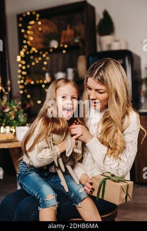 Glückliche Mutter und Tochter Eröffnungsgeschenke am Heiligabend Stockfoto