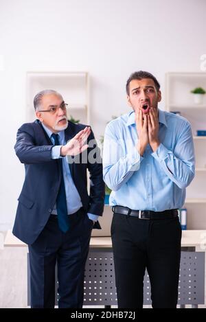 Der alte Chef und seine junge Assistentin im Büro Stockfoto