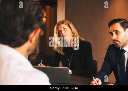 Serious Legal Kollegen hören zu reifen Geschäftsmann während der Sitzung bei Anwaltskanzlei Stockfoto