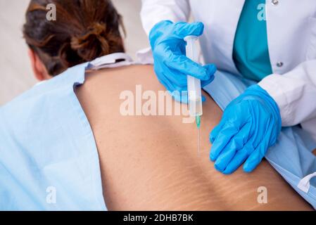 Junge Rücken verletzten Mann Besuch weibliche Arzt Chiropraktiker Stockfoto