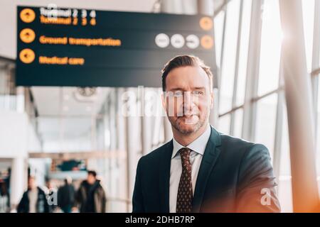 Porträt des selbstbewussten reifen Geschäftsmann im Flughafen-Terminal Stockfoto