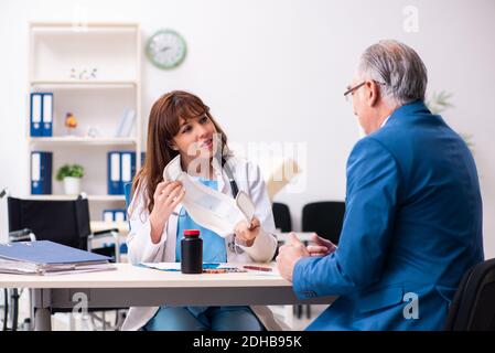 Alter Geschäftsmann besucht junge Ärztin Stockfoto