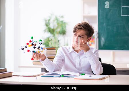 Schuljunge hält molekulares Modell im Klassenzimmer Stockfoto
