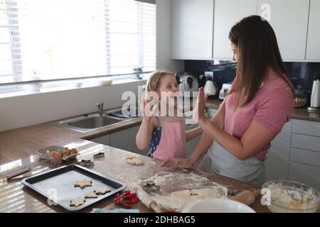 Kaukasische Mutter und Tochter mit Spaß Backen in der Küche, hohe Fiving Stockfoto