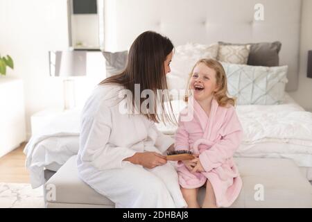 Kaukasische Frau und Tochter Spaß im Schlafzimmer Stockfoto