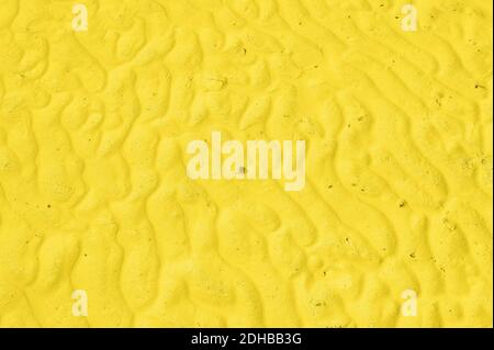 Die Textur der Wellen auf dem hellen, glatten Sand Stockfoto