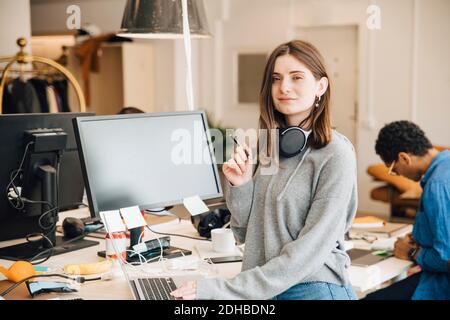 Portrait von lächelnden weiblichen Computer-Programmierer mit Laptop am Schreibtisch Im Büro Stockfoto