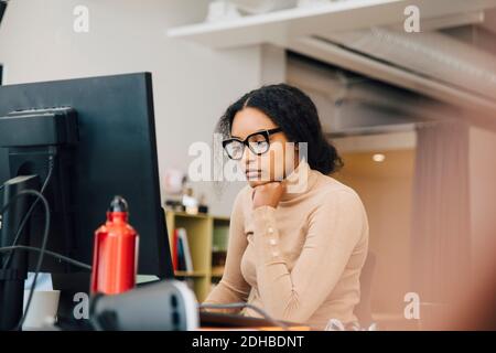 Fokussierte weibliche Computerprogrammiererin, die am Laptop am Schreibtisch arbeitet Büro Stockfoto