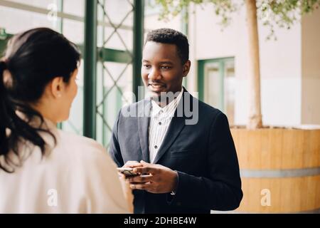 Ein Geschäftsmann, der mit einer Kollegin in einem Meeting im Büro kommuniziert Stockfoto