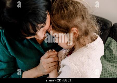 High-Angle-Ansicht der Mutter hält traurig Tochter während sitzen Zu Hause Stockfoto