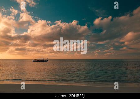 Maldives Sunset Cruise mit Dhoni Boot auf den Malediven Inseln. Tropischer Sonnenuntergang, Meereslandschaft. Menschen, die den Sonnenuntergang genießen und Meeresleben suchen Stockfoto