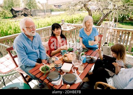 Familie mit mehreren Generationen, die das Essen am Tisch auf der Terrasse genießt Stockfoto