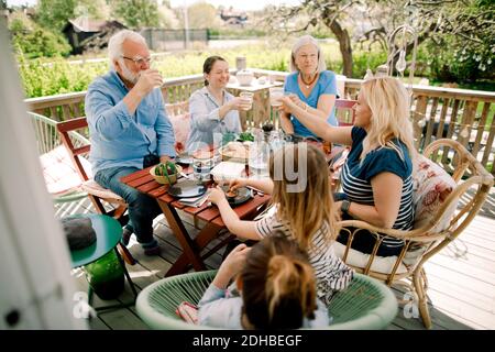 Mehrere Generationen Familie Toasting Gläser während sitzen am Tisch auf der Terrasse Stockfoto