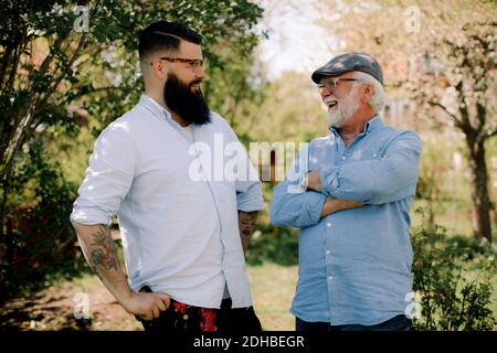 Glücklicher Vater und Sohn reden, während im Hof stehen Stockfoto