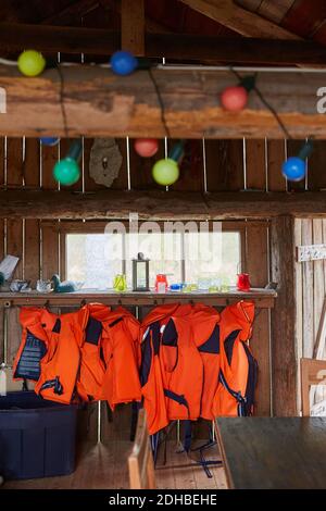 Schwimmwesten hängen auf Holz in der Kabine Stockfoto