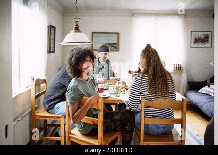 Porträt einer lächelnden jungen Frau, die sich mit Freunden gesellt Zu Hause Stockfoto