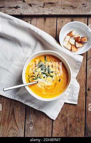 Kürbiscremesuppe mit Croutons auf rustikalem Holzhintergrund, Draufsicht. Stockfoto