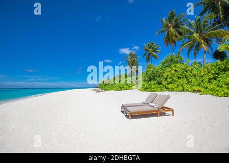 Wunderschöne tropische Landschaft, zwei Sonnenliegen, Liegen, Sonnenschirm unter Palmen. Weißer Sand, Meeresblick Horizont. Reisen Landschaft, Sommer Strandurlaub Stockfoto