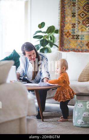 Berufstätigen Mutter im Gespräch mit liebevollen Tochter während der Verwaltung ihres Geschäfts Vom Heimbüro Stockfoto