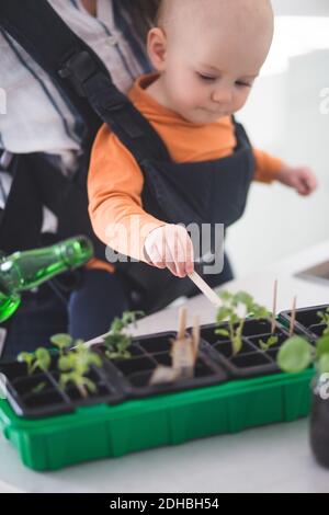 Baby-Mädchen im Garten, während sie von der Mutter zu Hause getragen Stockfoto