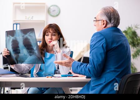 Alter Geschäftsmann besucht junge Ärztin Stockfoto