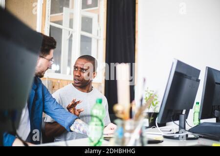 Seriöse männliche IT-Profis diskutieren während der Arbeit am Schreibtisch Büro Stockfoto