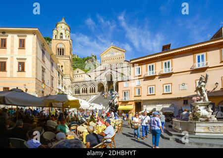 Touristen drängen die kleine Piazza del Duomo umgeben von Cafés, Geschäften und die Schritte zur Amalfi Kathedrale in Amalfi, Italien Stockfoto