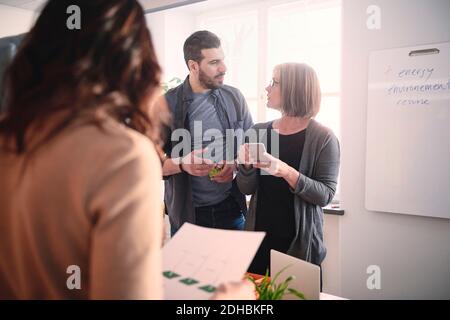 Männlicher Ingenieur, der während des Meetings im Büro mit einer Kollegin spricht Stockfoto