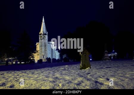 St. Bartholomew's Kirche und Kirchhof, Welby Lincolnshire im Schnee in der Nacht im Winter Dezember Stockfoto