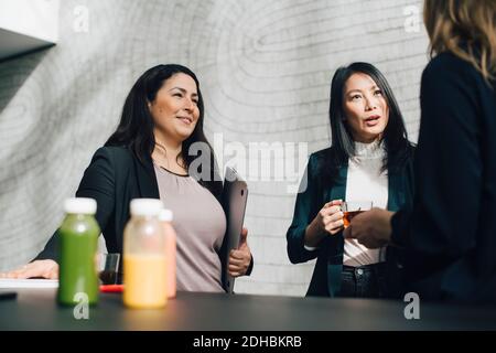 Multiethnische Geschäftsleute diskutieren bei einem Drink auf der Konferenz Stockfoto