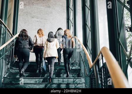 Low-Angle-Ansicht der multi-ethnischen Unternehmerinnen, die nach oben ziehen Treppe im Büro Stockfoto