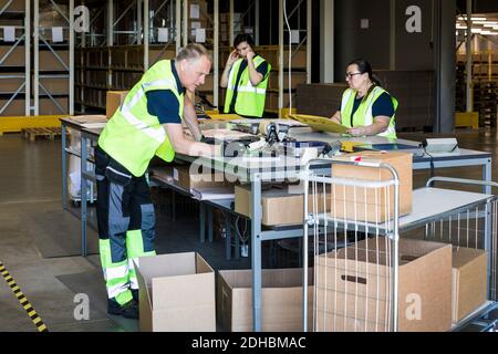 Multiethnische Arbeiter, die Waren im Verteilungslager verpacken Stockfoto