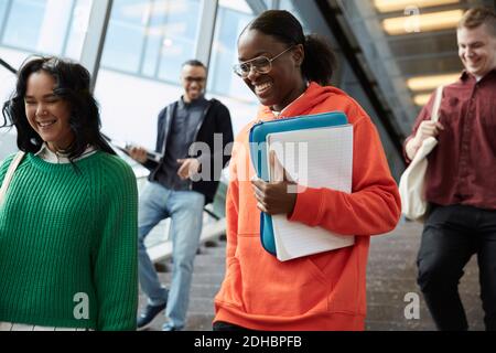 Blick aus der Nähe auf glückliche Schüler, die auf Stufen hinuntergehen In der Universität Stockfoto