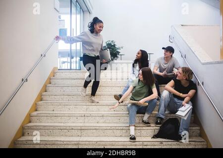 Lächelnde multiethnische Studenten auf der Treppe in der High School Stockfoto