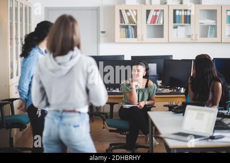 Lächelnd weibliche Gymnasiasten mit Lehrer im Computer-Labor Stockfoto