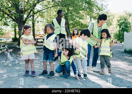 Multiethnische Vorschulkinder und Lehrer auf dem Spielplatz Stockfoto