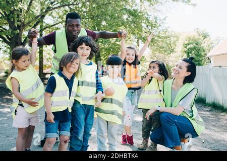 Multiethnische Vorschulkinder und Lehrer genießen auf dem Spielplatz Stockfoto